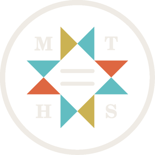 A logo for the Montana Historical Society composed of a circle with eight triangles in different colors arranged to mimic a quilt square. The letters "M", "T", "H", and "S" are arranged around the quilt configuration.